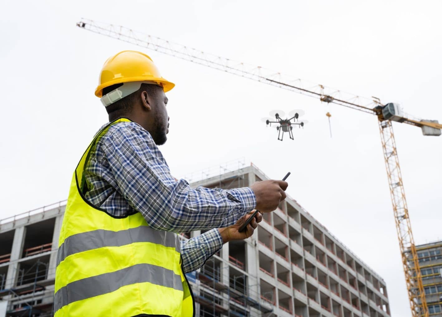 Construction worker flying drone at construction site