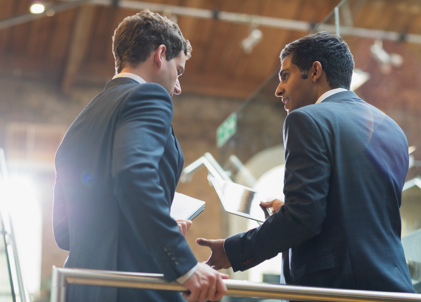 Businessmen talking with digital tablet in office