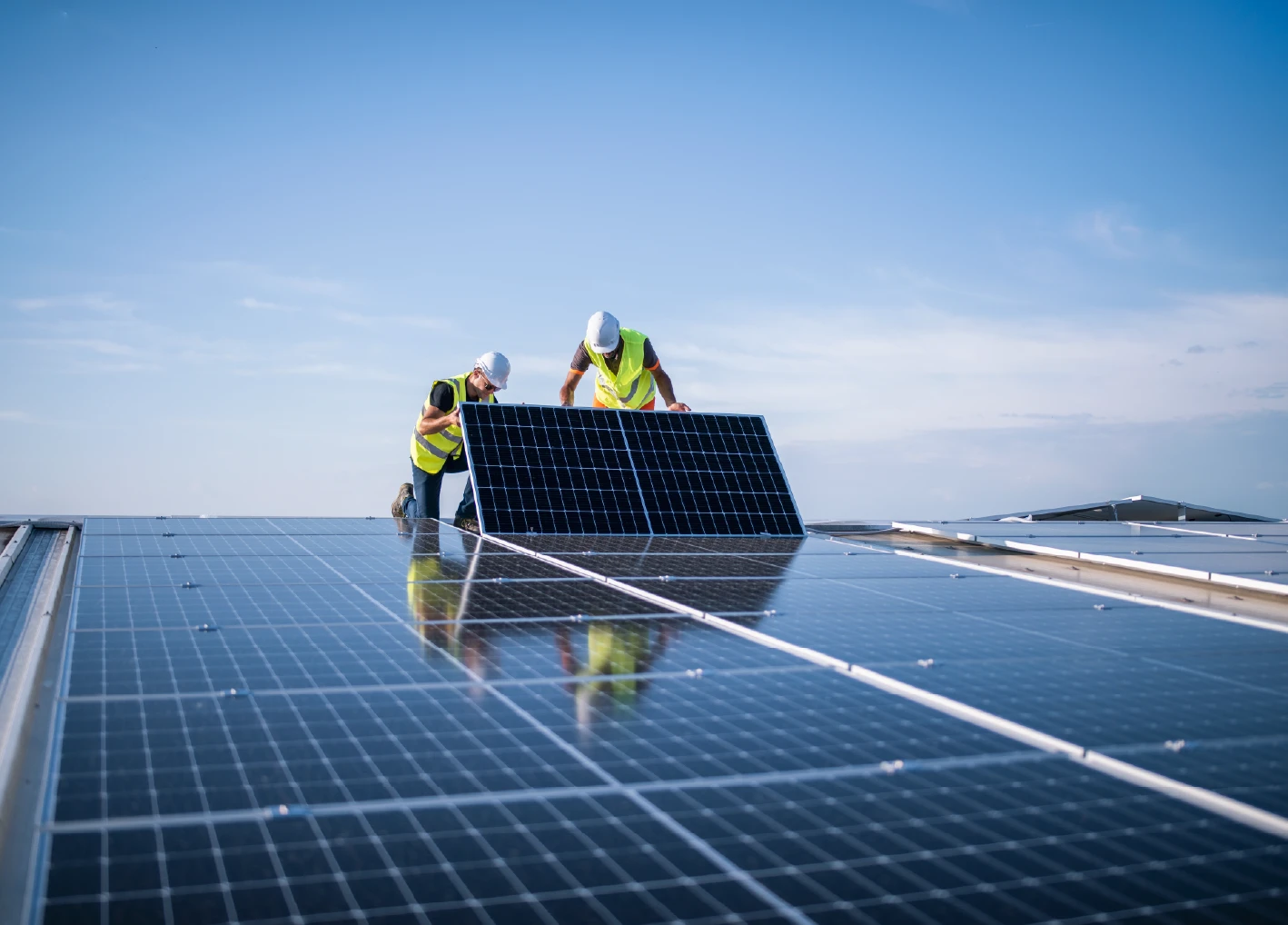 Two construction workers installing solar panels