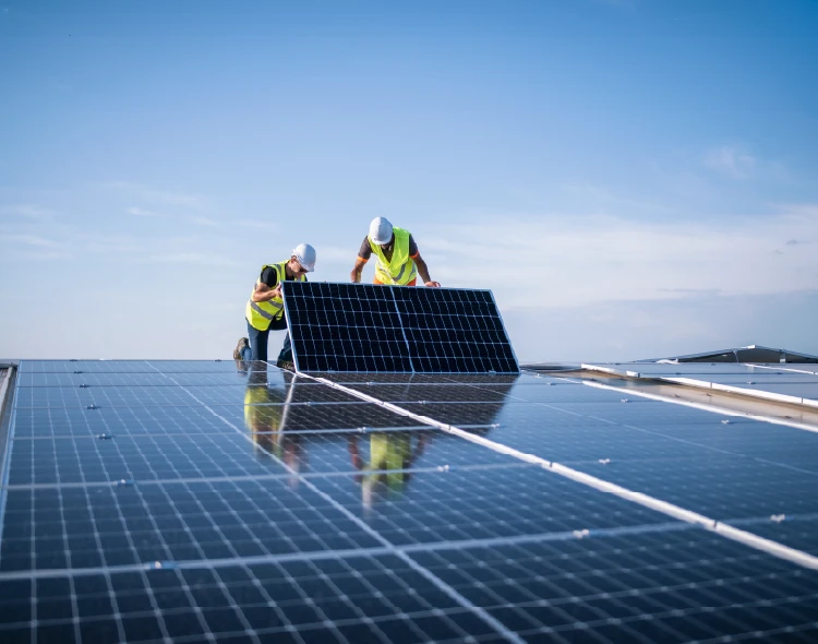 Two construction workers installing solar panels