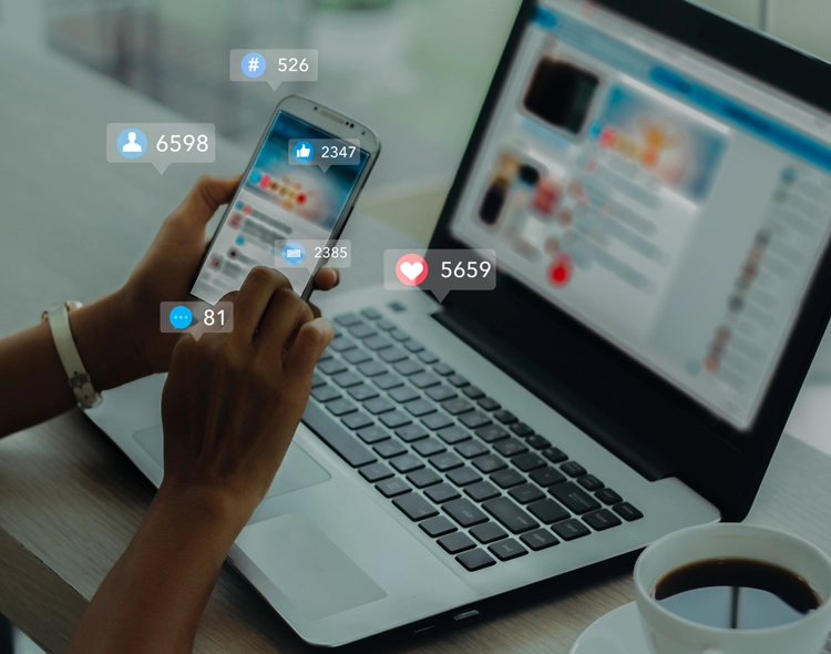 Social media icons displaying over smart phone and laptop